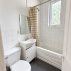 Salle de bain commune avec baignoire et fenêtre au 703 rue de Cadillac.